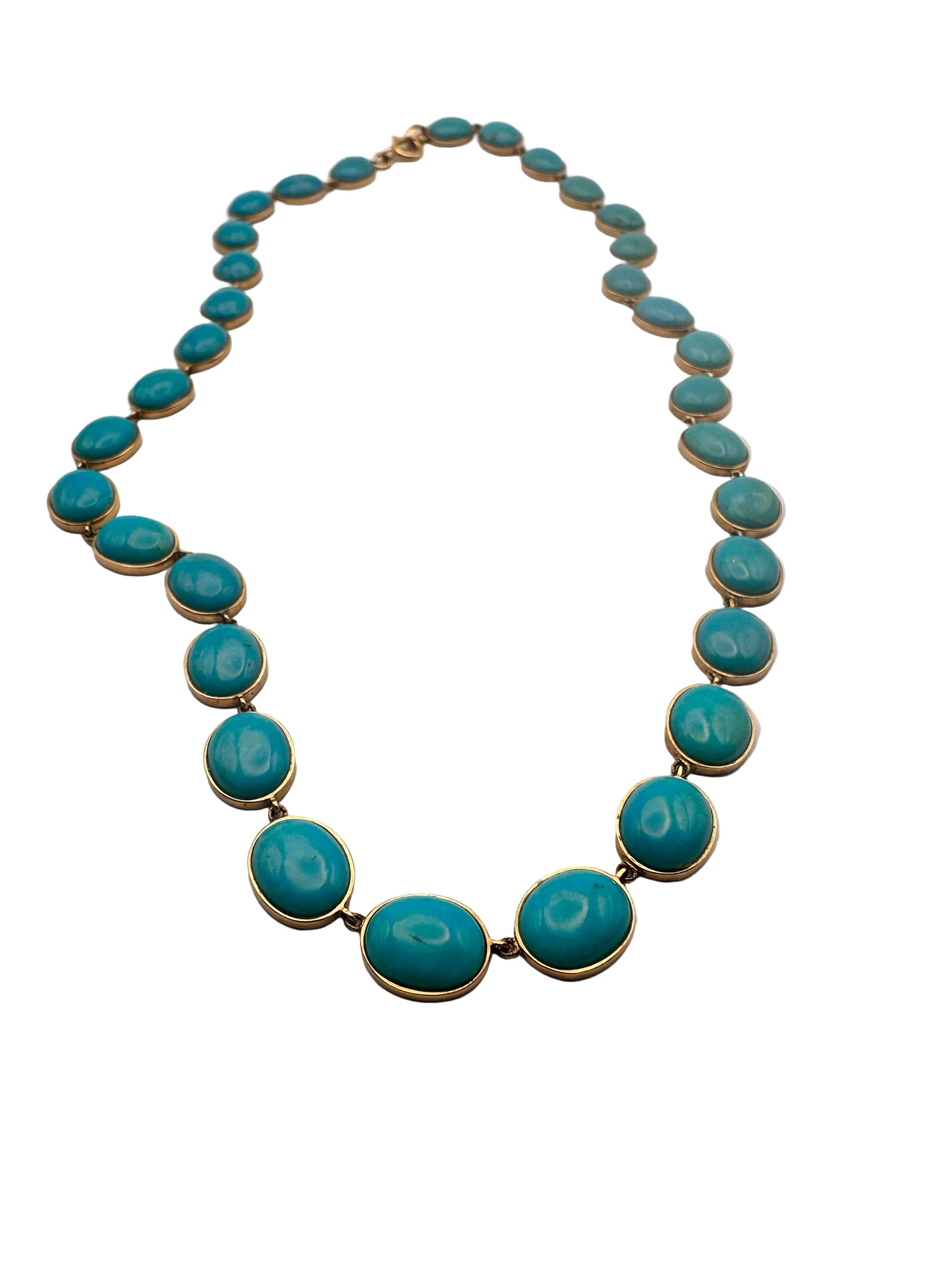 Turquoise necklace with gold accents on a light gray background