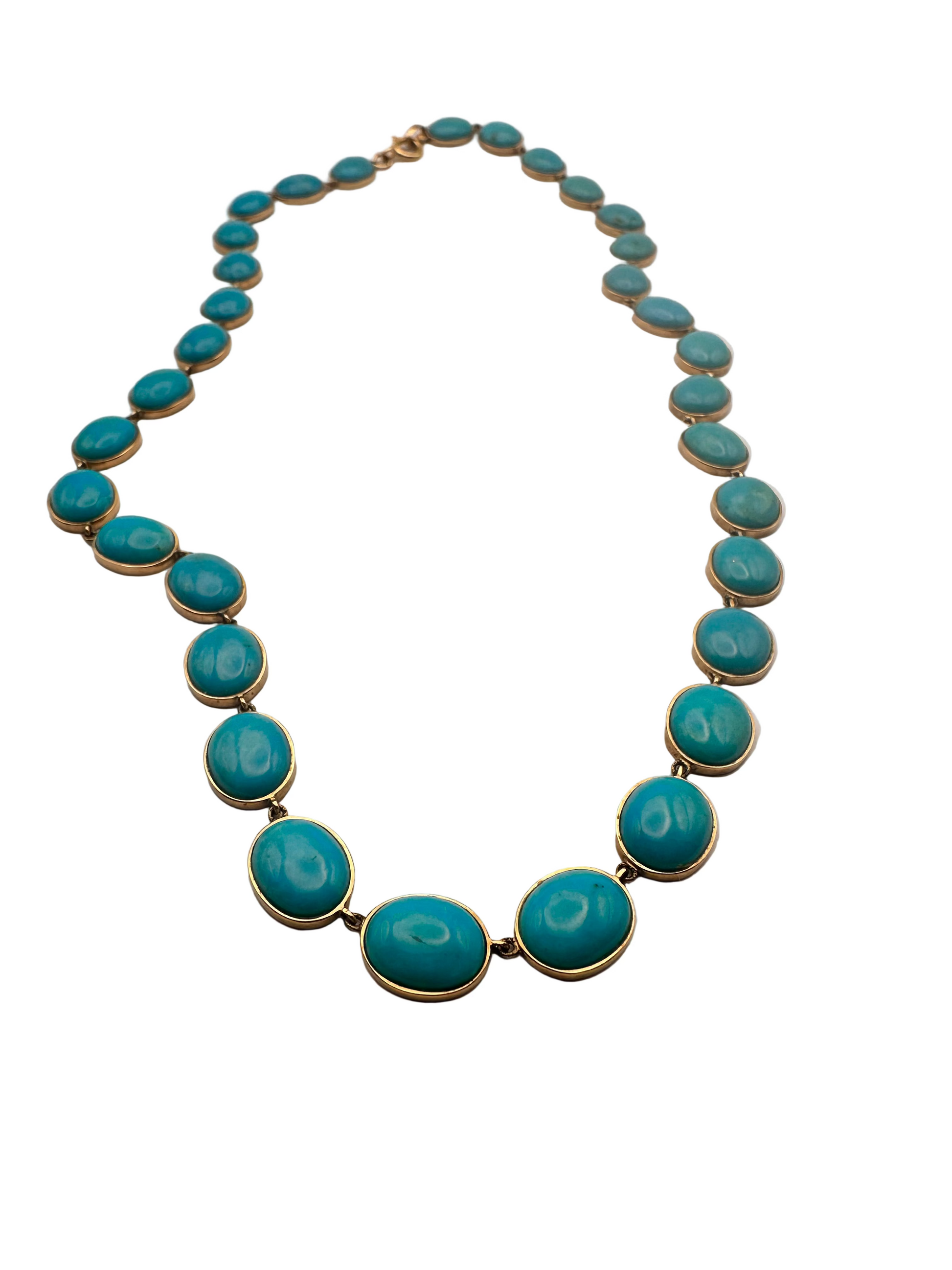 Turquoise necklace with gold accents on a light gray background