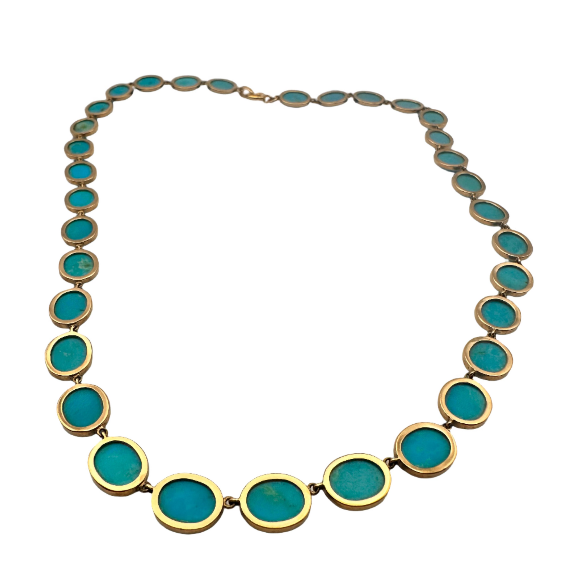Necklace with turquoise stones and gold accents on a light gray background