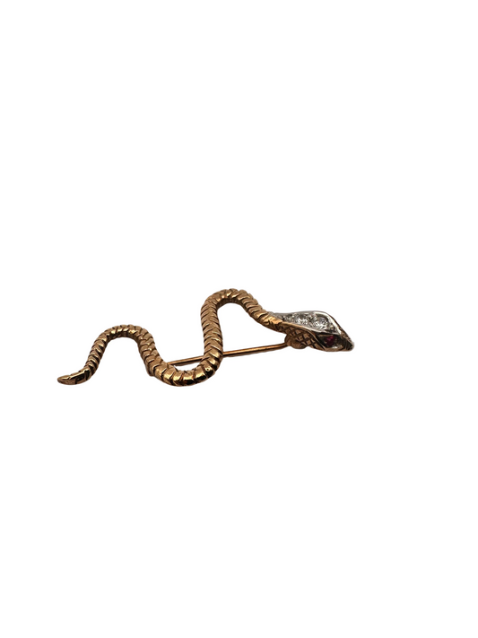 Gold snake-shaped brooch on a light gray background